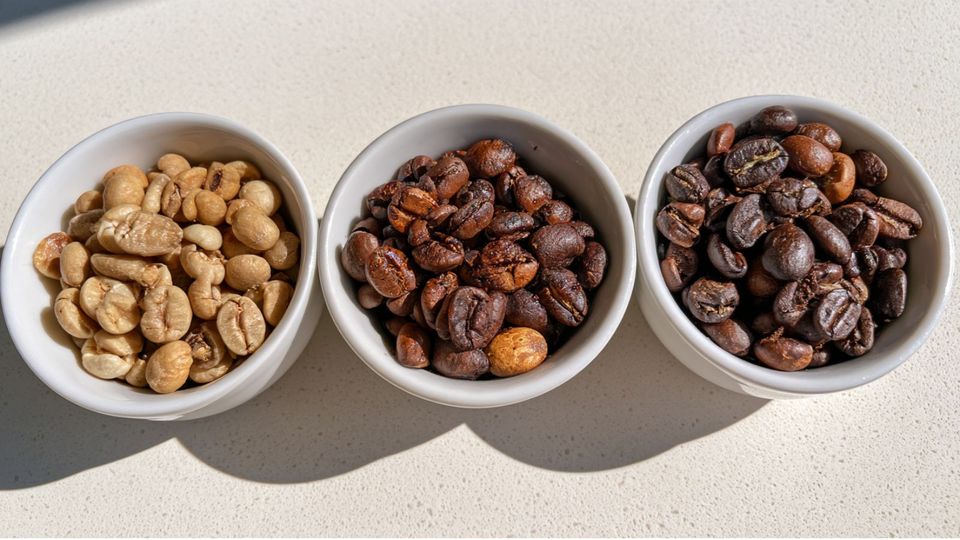 Three small bowls comparing light, medium, and dark roast coffee beans side by side